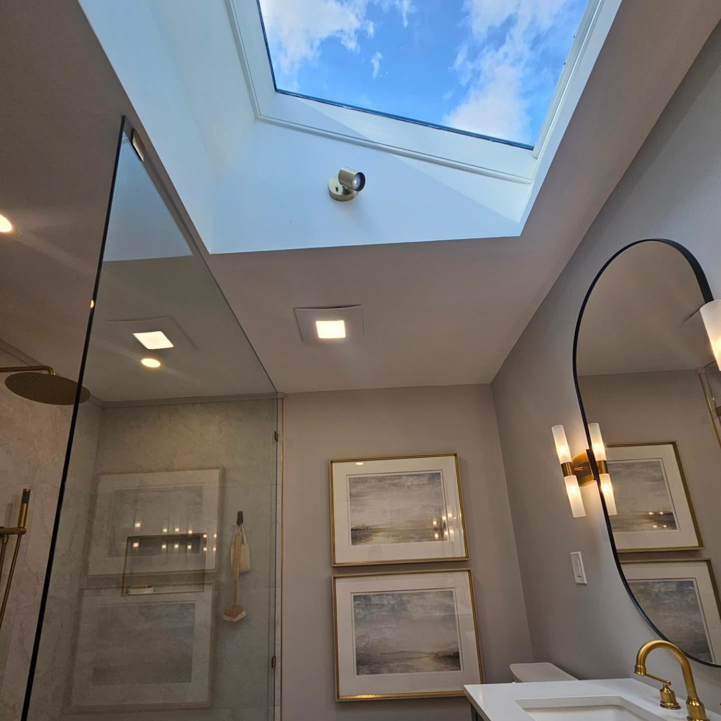 Bathroom renovation with skylight and custom glass shower